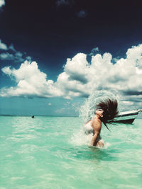 Side view of man splashing water in sea