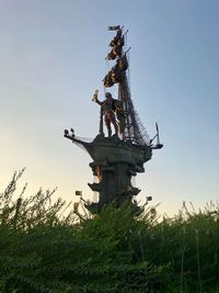 Low angle view of statue on field against sky