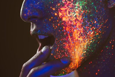 Close-up of man with multi colored face paint