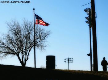 Low angle view of american flag against blue sky