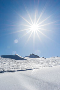 Scenic view of snowcapped mountains against sky on sunny day