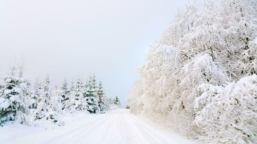 Snow covered road against clear sky