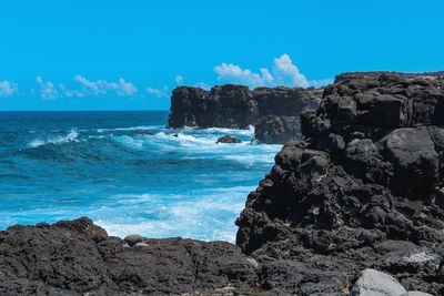 Scenic view of rocky beach against sky