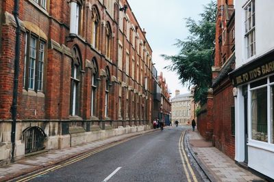 Road amidst buildings in city against clear sky