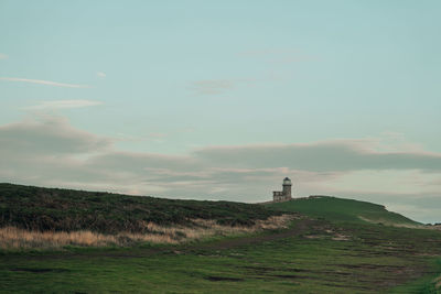 Scenic path towards the lighthouse by the seven sisters chalk cliffs in east sussex, uk, at sunset.