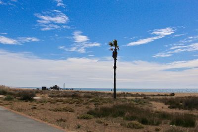 Scenic view of road by sea against sky