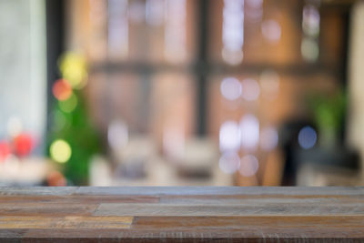 Defocused image of illuminated lights on table by window