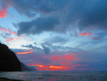 Scenic view of sea against dramatic sky during sunset