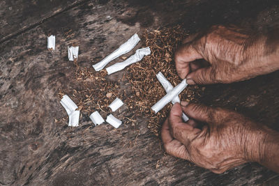 Cropped hands holding cigarettes outdoors