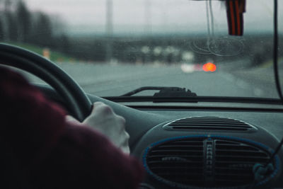 Man seen through car windshield