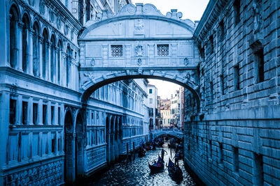 Bridge of sighs over canal amidst buildings