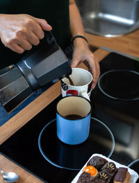 Midsection of man preparing coffee cup