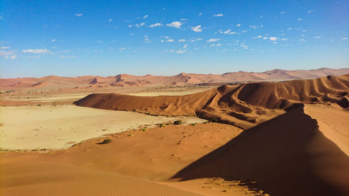 Sand dunes in desert against sky