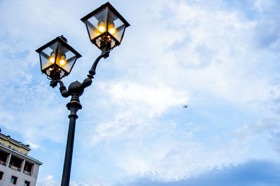 Low angle view of illuminated street light against sky