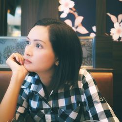 Woman looking away while sitting at restaurant