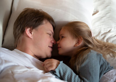 Father and daughter lying on bed