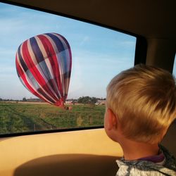 Close-up of boy looking through window