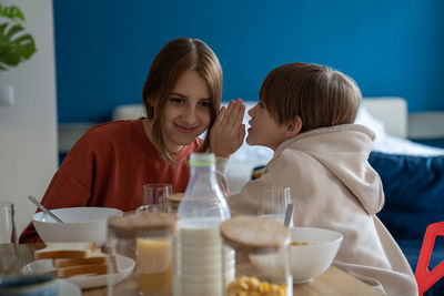 Side view of woman drinking glass on table