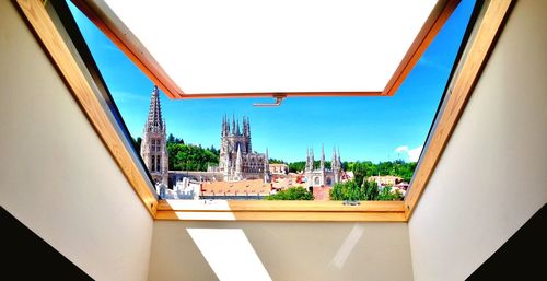 Buildings against clear sky seen through glass window