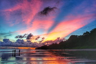 Scenic view of sea against dramatic sky during sunset