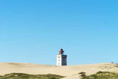 Low angle view of lighthouse against clear blue sky