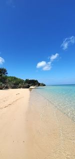 Scenic view of beach against blue sky