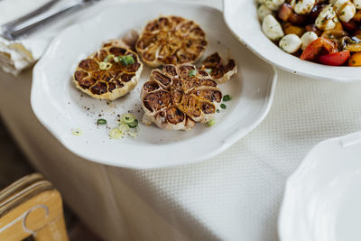 Roasted garlic dish in olive oil in luxury restaurant. white beautiful restaurant europe style.