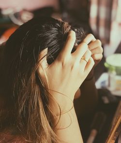 Close-up of tensed woman with hands in head at home