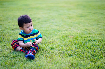 Cute girl playing with ball on grassy field