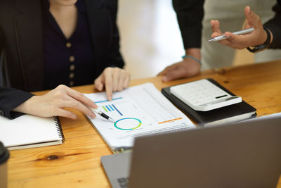 Midsection of business colleagues working on table