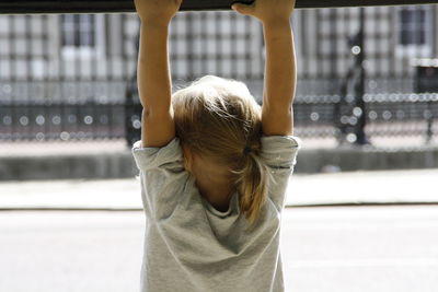 Rear view of girl standing in park looking at buckingham palace.