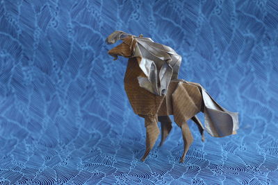 Close-up of paper horse on blue backdrop