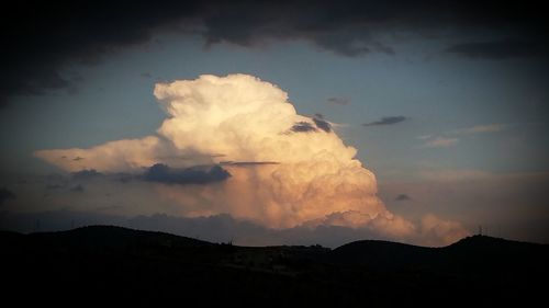 Silhouette of mountain against cloudy sky