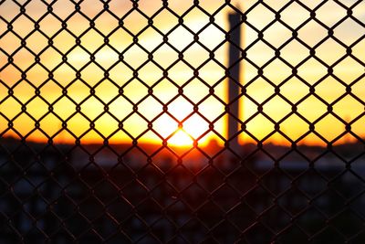 Close-up of chainlink fence during sunset