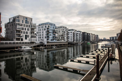 Boats moored in river against buildings in city