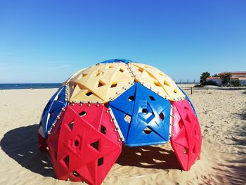 Umbrella on beach against clear sky