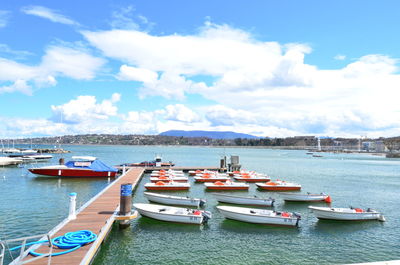 Sailboats moored in sea against sky