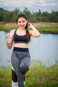 Woman drinking water while standing on road