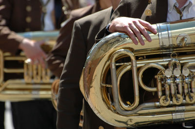 Midsection of man playing trumpet on street