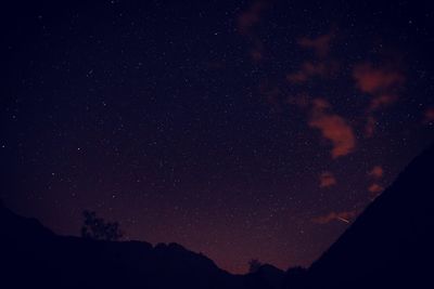 Low angle view of silhouette mountain against sky at night