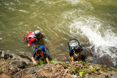 High angle view of people on rock by sea