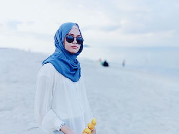 Young woman wearing hijab at beach