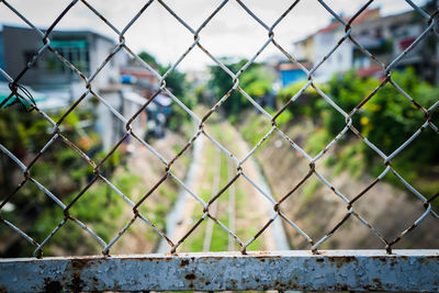 Close-up of chainlink fence against sky