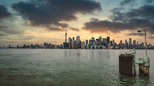 Panoramic view of sea and buildings against sky during sunset