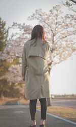 Rear view of woman walking on road