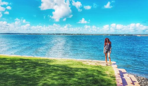 Rear view of man looking at sea against sky