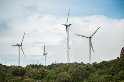 Windmills on landscape against sky