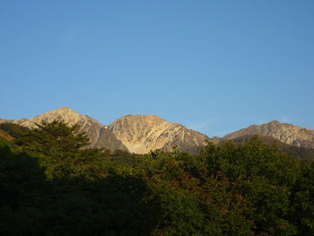 Scenic view of mountains against clear blue sky