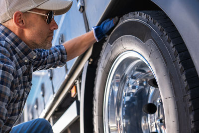 Midsection of mechanic repairing car