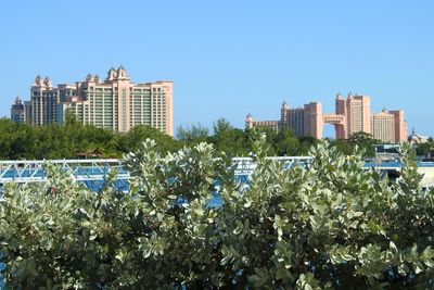 Low angle view of city against clear blue sky